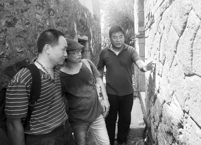 盧信守（右）向邀請來的臺灣團隊介紹小練島的石頭厝。