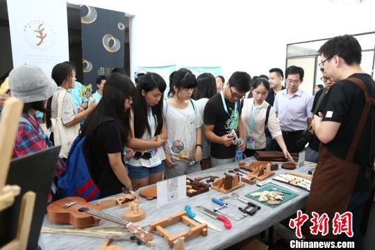福州市良木智造文化創意有限公司負責人林傑民為兩岸青年介紹人氣木製文創産品。　阿澤 攝