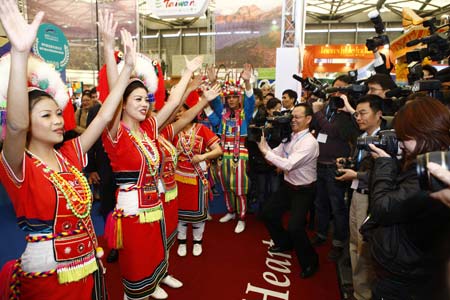 Journalists take photos of girls of Gaoshan ethnic group performing traditional dance at the Taiwan stand during the World Travel Fair 2009 in Shanghai, east China, on April 9, 2009. The fair, opening on Thursday at the Shanghai New International Expo Center, attracted more than 450 exhibitors from over 50 countries and regions. (Xinhua/Pei Xin)