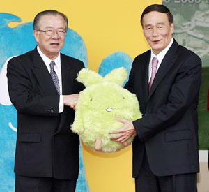 Masaaki Kanda (L), governor of Aichi Prefecture, presents the mascot of the 2005 Aichi World Exposition "Kiccoro" to Chinese Vice Premier Wang Qishan in Aichi Prefecture, Japan, June 9, 2009.