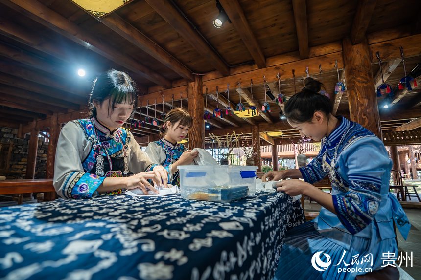 身著民族服飾的布依族姑娘正在製作布依族特色扎染手工藝品。人民網 涂敏攝