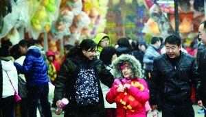 昨天，在北京石景山遊樂園，遊客在雪中逛廟會。 　　首席攝影記者　蔡代徵/攝