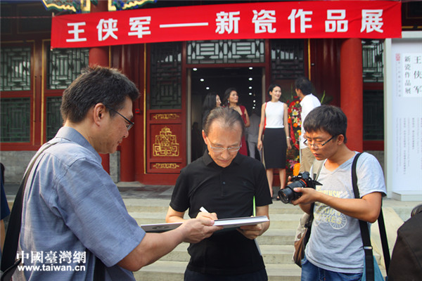 臺灣藝術家王俠軍（左二）為觀眾簽名。（台灣網 郜利敏 攝）