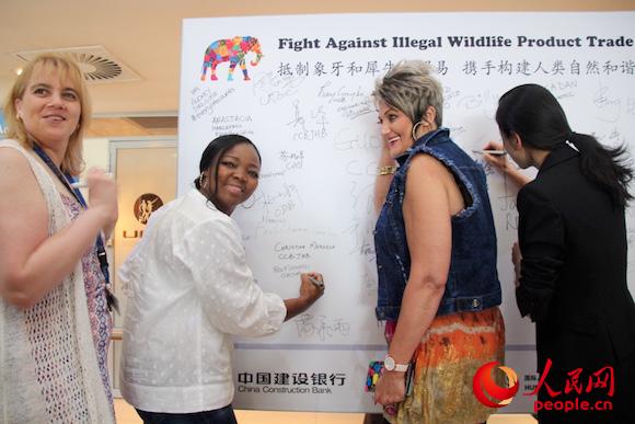 9月23日，南非中資企業員工響應“抵制象牙和犀牛角貿易，攜手構建人類自然和諧”簽名倡議。圖為中國建設銀行約翰內斯堡分行本地員工簽字。人民網 張潔嫻 攝