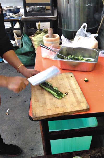 昨日，豐臺望園東路一燒烤店，店員在室外拍黃瓜售賣。