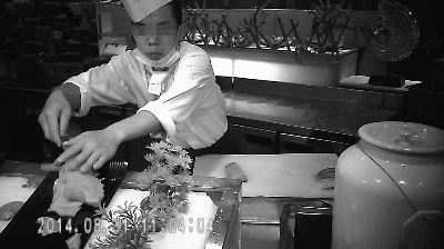  8月31日，一名廚師正將切好的生魚片放在取餐臺的托盤上 攝/法制晚報暗訪組