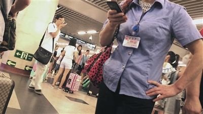 7月4日，北京西站A2齣口，一名“醫托”胸口挂著“北京西站工作證”。