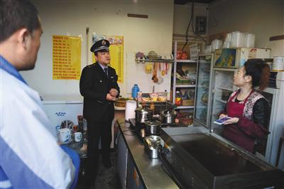 昨日下午，豐台區食藥監局執法人員查處涉嫌違法經營的“臺灣手抓餅”店，並對經營者進行詢問。新京報記者 吳江攝
