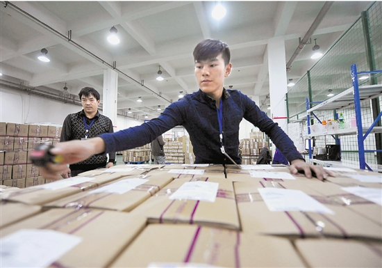 國務院批准杭州跨境電子商務綜合試驗區後，更多的“國際包裹”將通過網購平臺完成交易。圖為去年“雙十一”時杭州一家物流公司的員工正在抓緊“掃貨”。 新華社發
