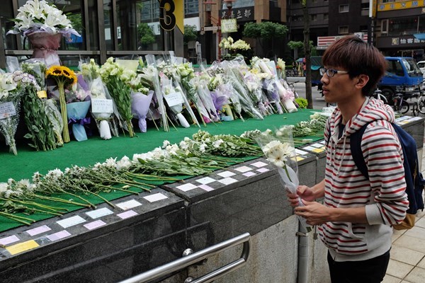 民眾到站外獻白花吊慰亡靈