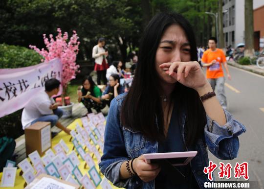 圖為看到櫻花標本想起即將畢業去德國，不知何時再回武大的女生當場淚奔。　趙小燕 攝