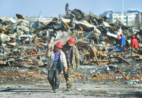 15日,工作人員在火災後的匡山酒水批發市場內清理現場。