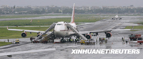 9月4日，在印度孟買的恰提拉帕提�希瓦吉國際機場，消防人員聚集在一架波音747飛機周圍。當日，印度航空公司一架飛機在孟買起飛前引擎突然起火，由於機上人員撤離及時，沒有造成傷亡。目前事故發生原因仍在調查之中。