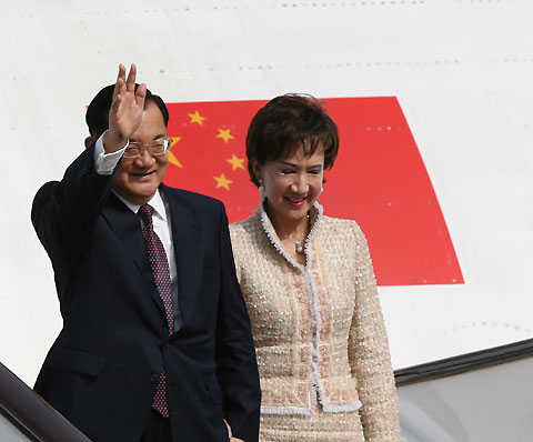 Lien Chan(C), former chairman of Taiwan's main opposition Kuomingtang party talks with China's Taiwan Affairs Office Director Chen Yunlin(L) as he arrives at Beijing International Airport with his wife Lien Fang Yu. Lien arrived in Chinese mainland calling for stronger trade ties with the mainland as a bridge to cross-strait peace and prosperity. [Xinhua]