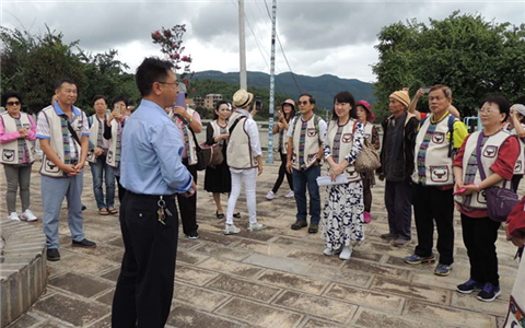 圖為巍山縣永建鎮永安村扶貧工作隊員為交流團一行介紹扶貧工作