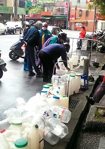 桃園市限水首日，龜山精忠裏的免費山泉水前等待裝水的空瓶、空桶大排長龍。