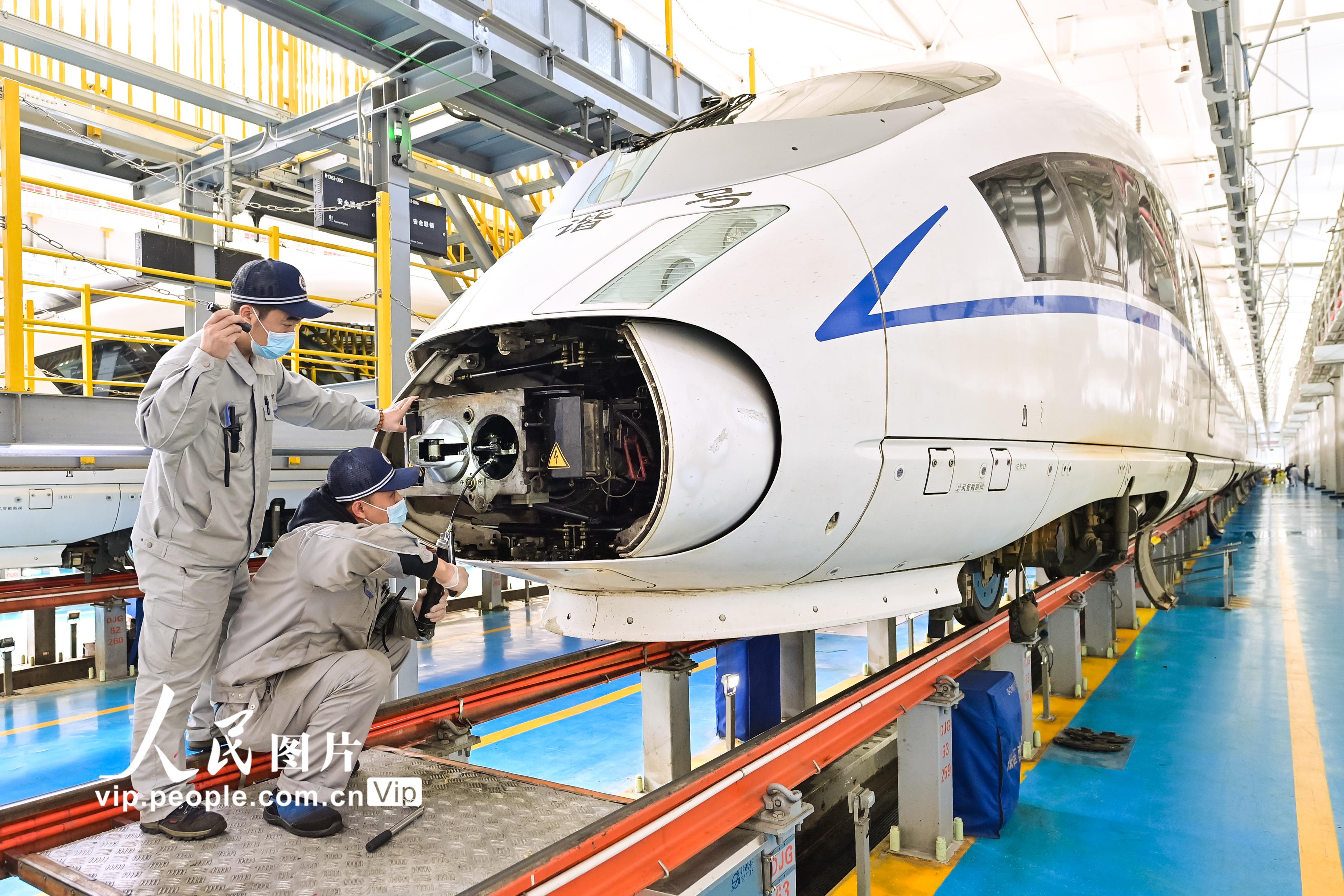 2022年3月25日，哈爾濱動車段檢修庫內，動車組機械師正在對動車車鉤進行檢查和清潔。