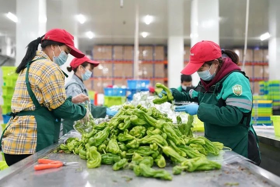 4月1日淩晨，工作人員在位於上海松江區的叮咚買菜蔬果大倉內忙碌。新華社記者丁汀攝