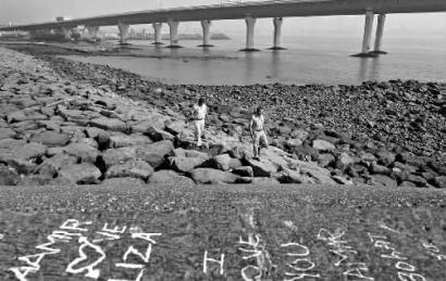 11日，搜救人員在班德拉的海灘搜尋落海的女孩兒