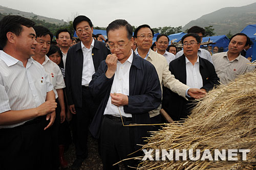 6月20日至22日，中共中央政治局常委、國務院總理溫家寶到受汶川大地震波及的陜西、甘肅災區檢查指導抗震救災工作，看望幹部群眾。這是6月21日，溫家寶在甘肅隴南市康縣豆坪鄉豆坪村口嚼麥粒，檢查搶收的小麥的品質。 新華社記者黃敬文攝