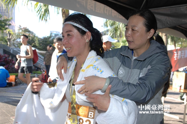 上海體育局有關領導為到達終點的跑者披上大毛巾。（台灣網發 葛鳳章 攝）