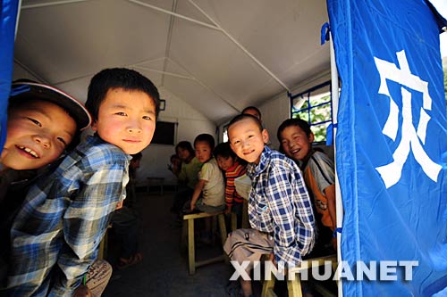 6月2日，在甘肅省隴南市武都區地震災區，石門鄉小山坪小學的學生在課間休息時從帳篷教室裏向外張望。 據介紹，經過社會各界及災區群眾的共同努力，甘肅隴南災區學校的復課工作取得很大進展。截至6月2日18時，隴南市已有1911所學校完全復課，229所學校部分年級復課，復課學校佔全部學校的74%，34.4萬名學生重新走入課堂。 新華社記者 張錳 攝