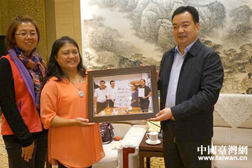 林清蘭（左）向王君正（右）贈送其訪問天埔社區時拍攝的照片