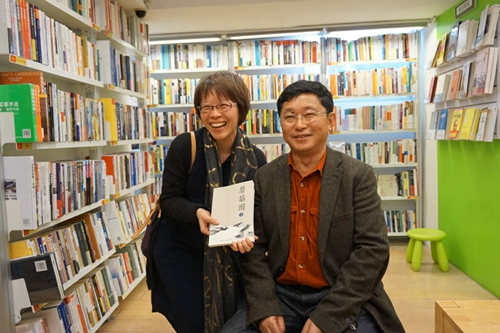 四川省作家協會主席阿來（右）在書店與現場購買自己作品的團員合影