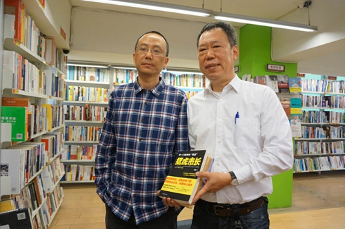 四川作家庹政（左）在書店與自己的作品《猛虎市長》合影