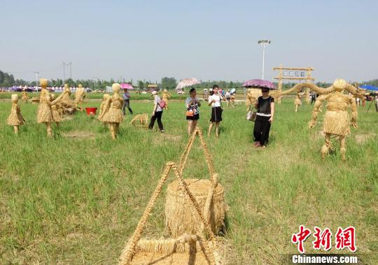 稻夢空間裏，各種用稻草編制的農耕場景吸引遊客留影。　鄧霞 攝