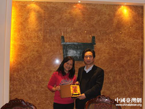 安阳市副市长姜海军向王丽芬女士赠送甲骨文片纪念品.