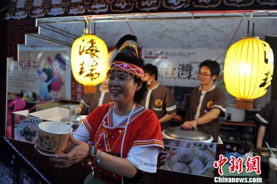 10月26日晚，一位身穿臺灣阿美族服飾的阿嬤在向民眾推介美味的臺灣小吃