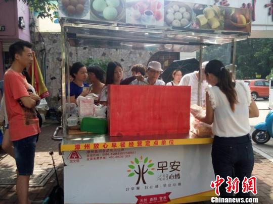 林宗榮夫婦推著早餐車到漳州市青少年宮門口賣臺灣早餐。　高淑萍 攝