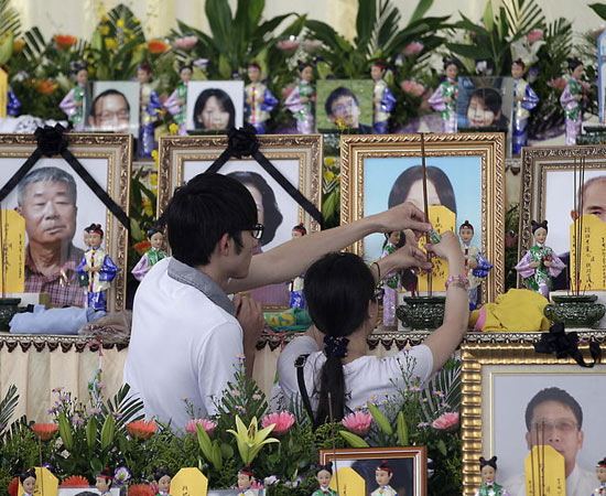 7月24日，臺灣澎湖，兩名親屬在遇難者的遺像前插香祭奠。