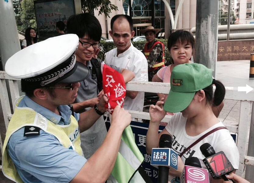深圳市民闖紅燈被罰戴綠帽執勤