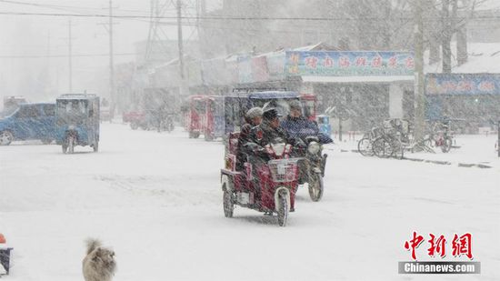 圖裏河鎮市民在雪中出行。