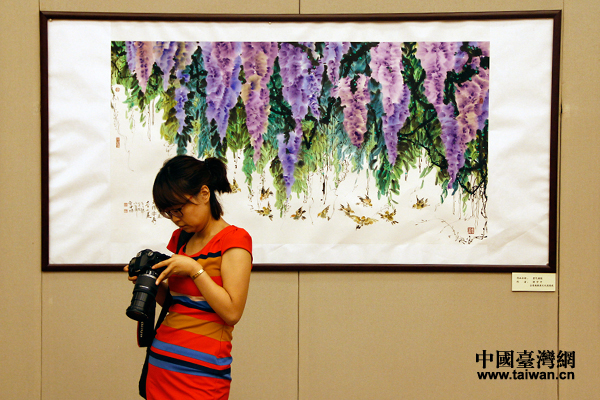 觀眾在臺灣畫家的作品《紫氣滿園》前駐足停留。