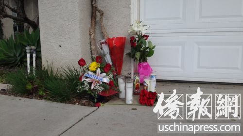 門口擺放著長明燈和鮮花,表達了人們對受害者黃閔的追思和悼念。(美國《僑報》/高睿 攝)