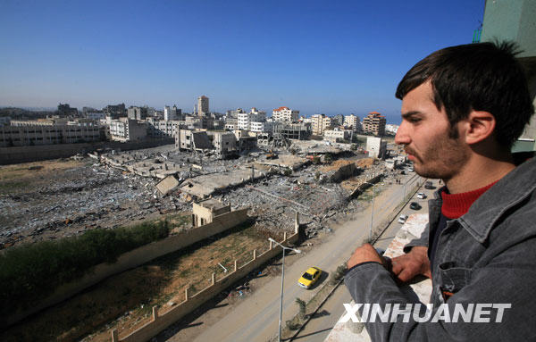 1月21日，一名巴勒斯坦人在加沙城中心的一幢樓內向外張望。以色列軍方一名發言人表示，以軍最後一名士兵已于當天淩晨撤離加沙地帶。以軍已經全部撤離加沙地帶。 新華社記者納賽爾攝