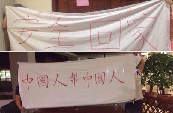 受困帛琉的陸客高舉“中國人幫中國人”布條，找臺灣駐當地代表機構幫忙