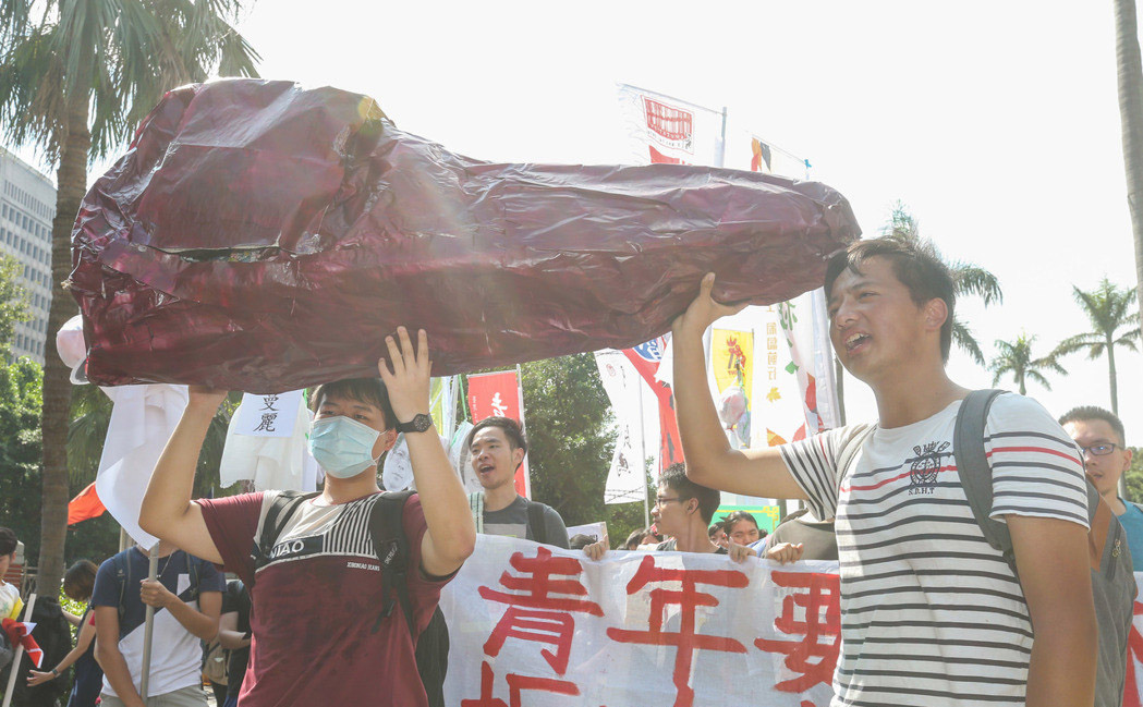 多個青年團體上午在“立法院”前集合，抬著象徵年輕人的“血汗肝”走到民進黨中央黨部表達抗議