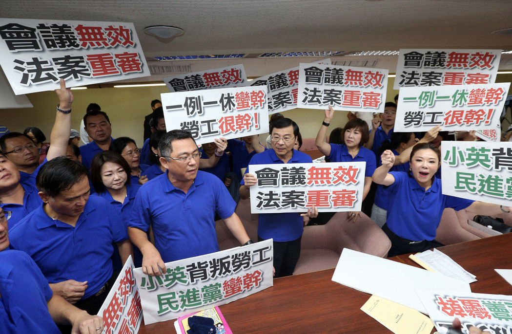 圖為國民黨“立委”高舉抗議標語，要求“一例一休”會議無效、“法案”重審