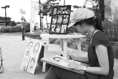 在街頭藝人嘉年華現場，藝術院校研究生擺攤作畫。