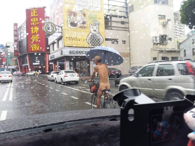 男子全裸撐傘騎腳踏車