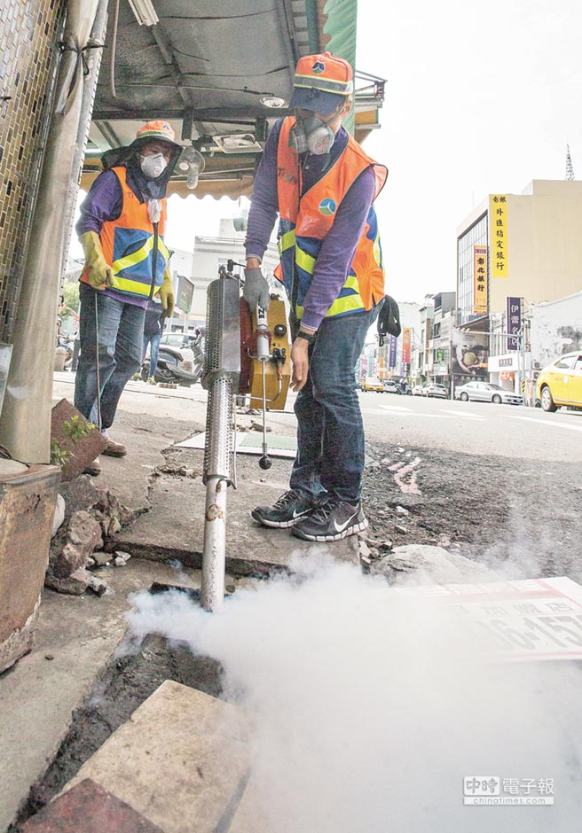 登革熱疫情持續嚴重，臺南市環保局工作人員到水仙宮市場外進行水溝消毒工作。（《中國時報》 黃仲裕攝）