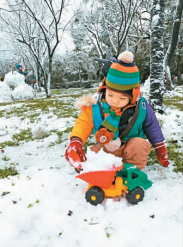 陽明山下雪，一位小朋友在雪地裏玩雪，體驗雪國風情。 　　蘇健忠攝