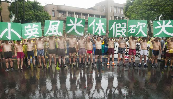 抗議的勞工，舉著標語站在“行政院”前高聲抗議