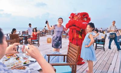 圖為馬爾地夫班多斯島上，中國遊客與舞獅合影留念。新華社記者 楊梅菊攝