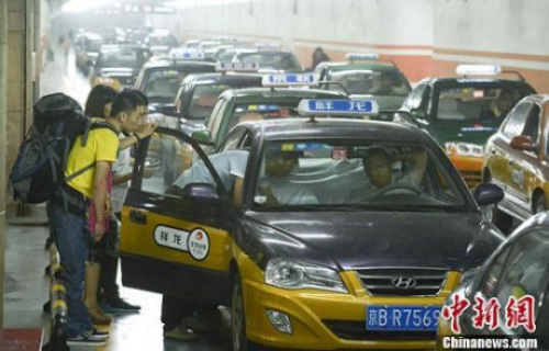 資料圖：市民在北京西客站計程車候車點準備乘車。中新社發 侯宇 攝