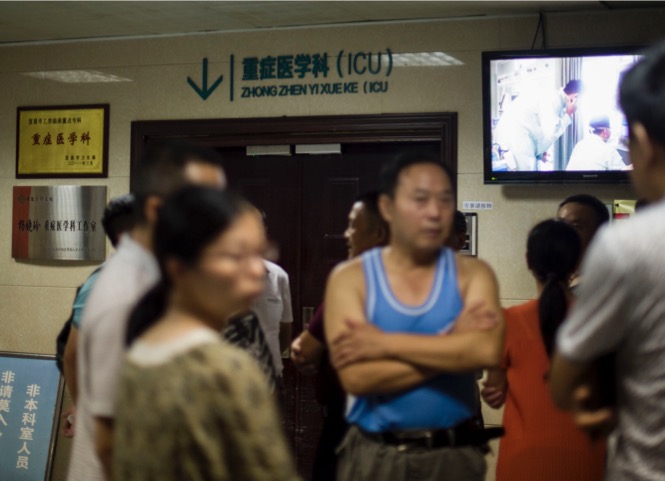8月11日，事故受傷人員家屬在當陽人民醫院ICU病房門口等待傷員救治的消息。